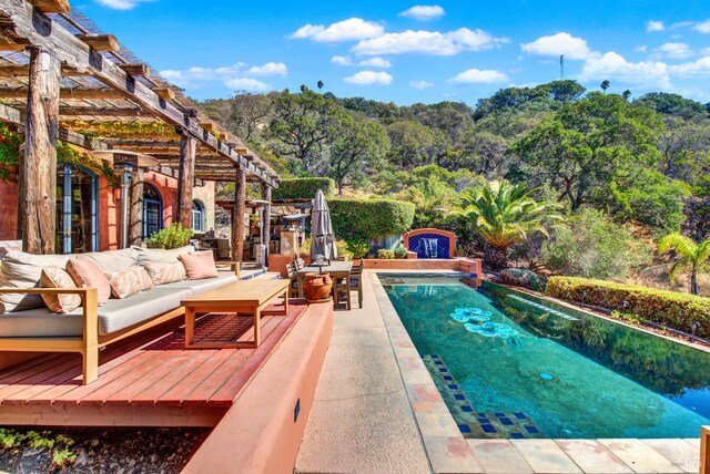 view of swimming pool featuring a patio, a pergola, and an outdoor living space