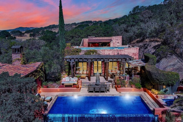 back house at dusk with a patio area