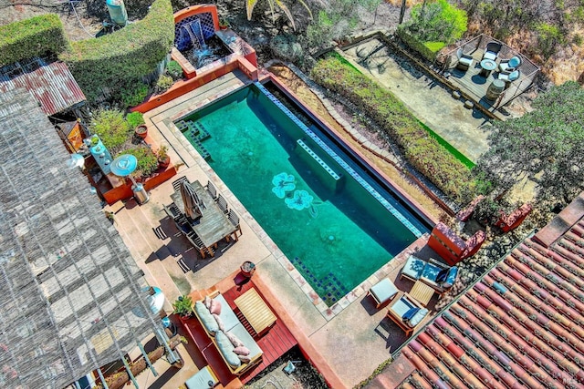 view of swimming pool featuring a patio and a hot tub