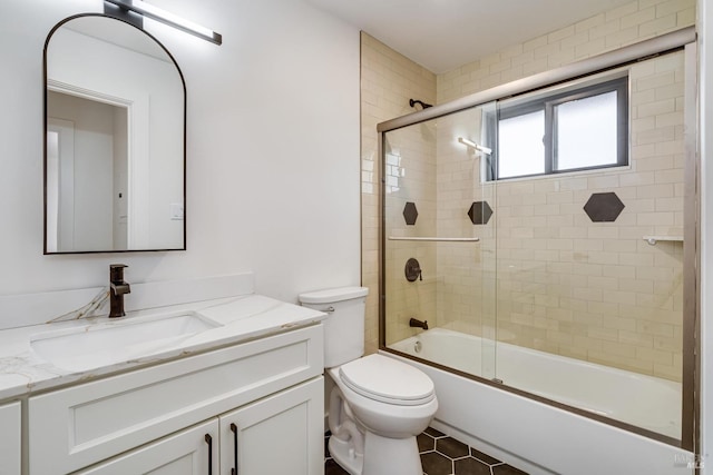 bathroom featuring toilet, shower / bath combination with glass door, tile patterned flooring, and vanity
