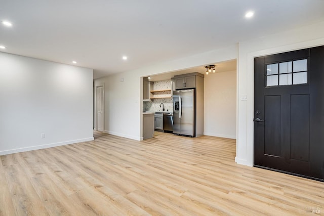 unfurnished living room featuring light wood-style flooring, baseboards, and recessed lighting