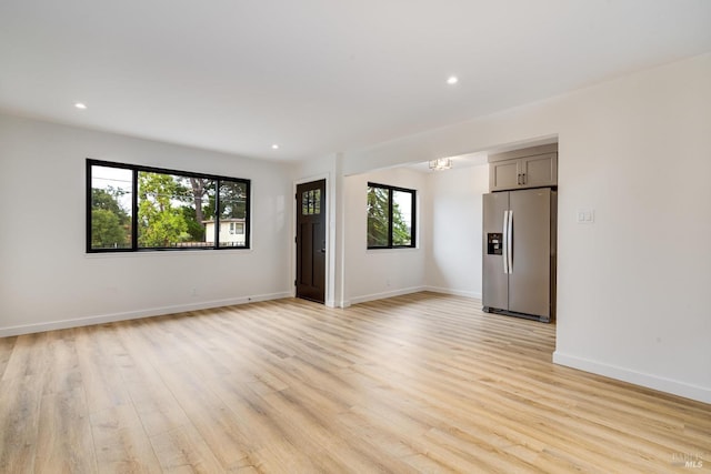 unfurnished room with light hardwood / wood-style floors and a notable chandelier