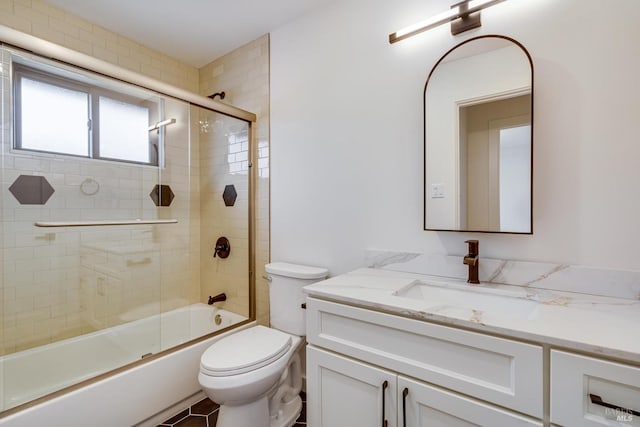 full bath with toilet, vanity, and bath / shower combo with glass door