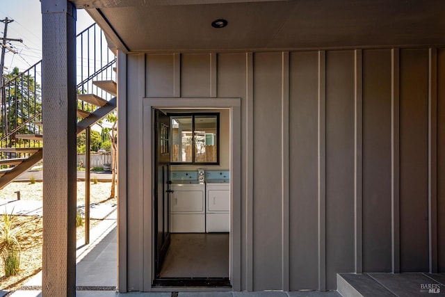 doorway to property with board and batten siding and washer and clothes dryer