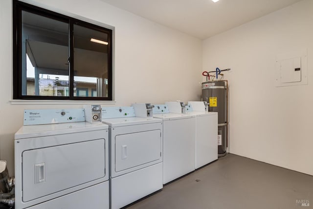 clothes washing area with electric water heater, electric panel, and washer and clothes dryer