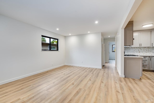 unfurnished living room featuring light wood-style flooring, baseboards, and recessed lighting