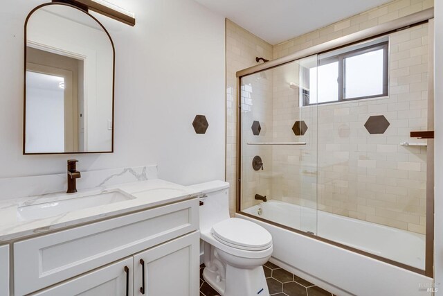 full bath with enclosed tub / shower combo, toilet, tile patterned flooring, and vanity