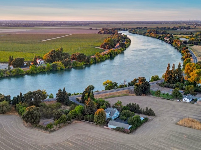 aerial view at dusk with a rural view and a water view