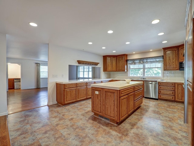10951 River Rd, Courtland, CA 95615 - kitchen with dishwasher, a center island, backsplash, kitchen peninsula, and light hardwood / wood-style floors