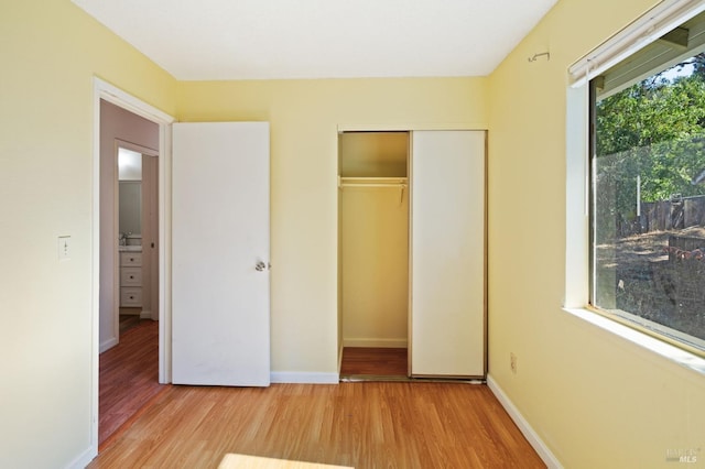 unfurnished bedroom featuring light hardwood / wood-style flooring and a closet