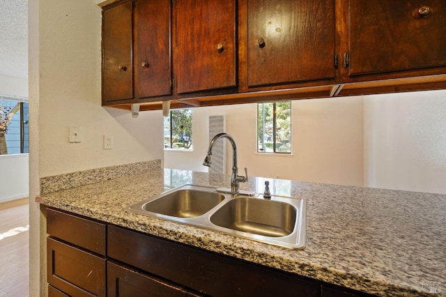 kitchen featuring sink and light stone counters