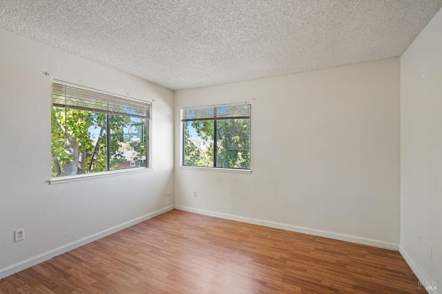 empty room featuring a textured ceiling and hardwood / wood-style flooring