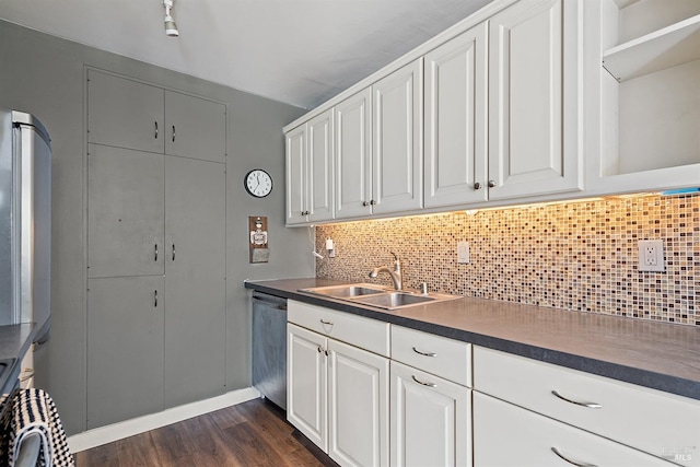 kitchen with white cabinets, a sink, dark wood-style flooring, dark countertops, and dishwasher
