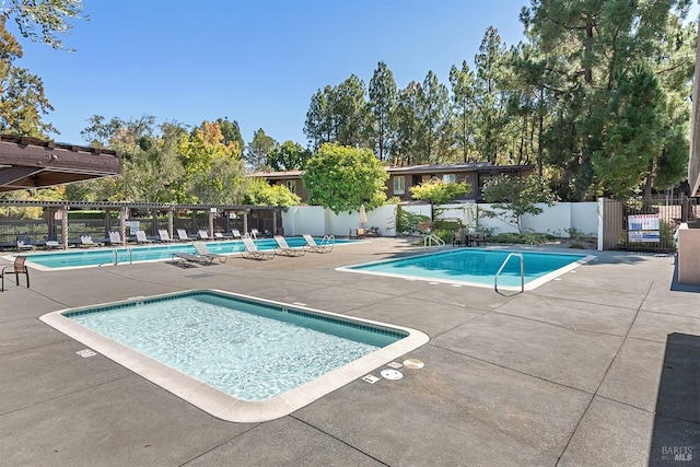 pool with fence and a patio
