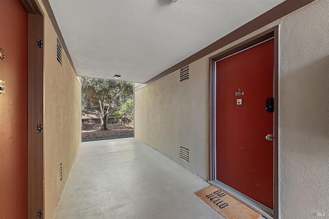doorway to property featuring stucco siding and a patio area