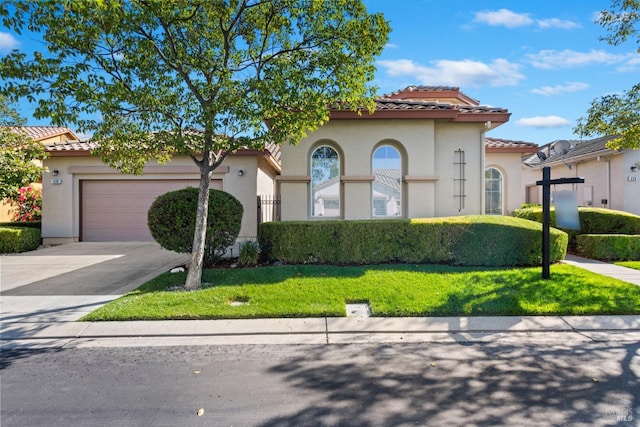 mediterranean / spanish-style home with a front yard and a garage