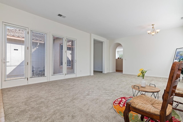 sitting room featuring light carpet and a notable chandelier