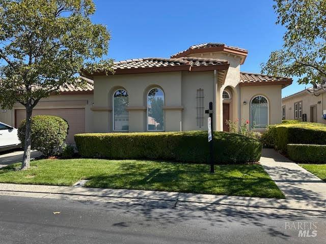 mediterranean / spanish-style home with a garage and a front yard