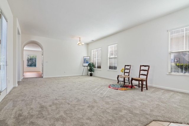 living area with light carpet and a chandelier