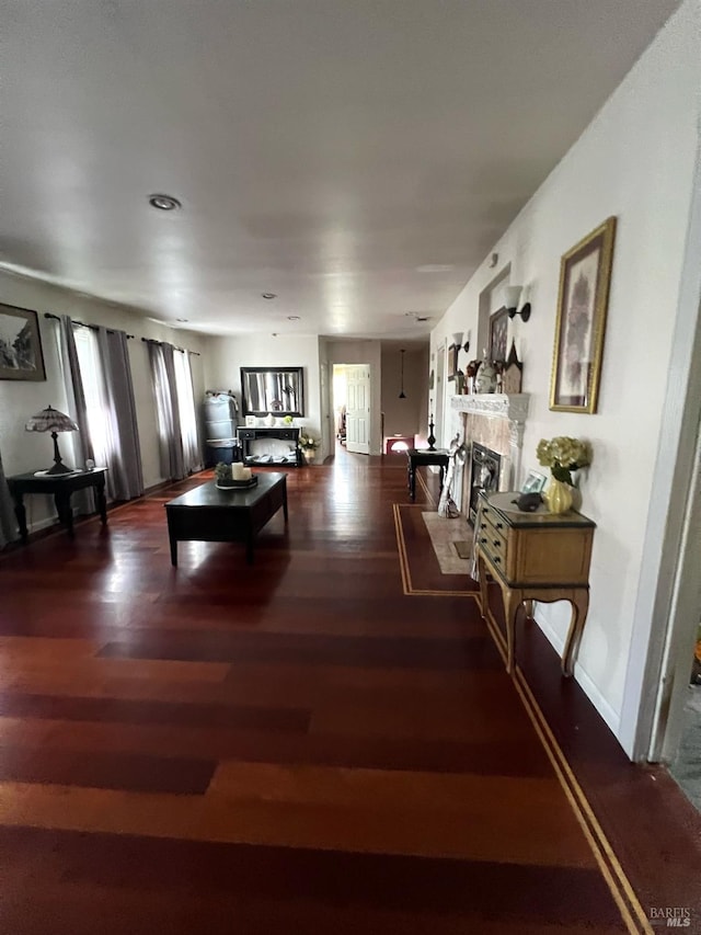 living area with a tile fireplace and wood finished floors