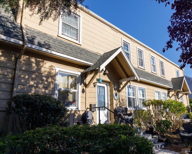 rear view of house featuring a shingled roof