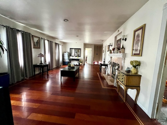 interior space with a fireplace with flush hearth, wood finished floors, and baseboards