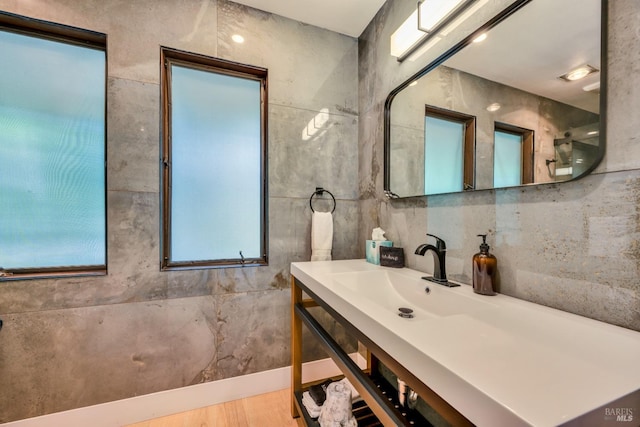 bathroom with tile walls, wood-type flooring, and vanity