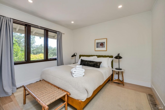 bedroom with crown molding and light hardwood / wood-style flooring