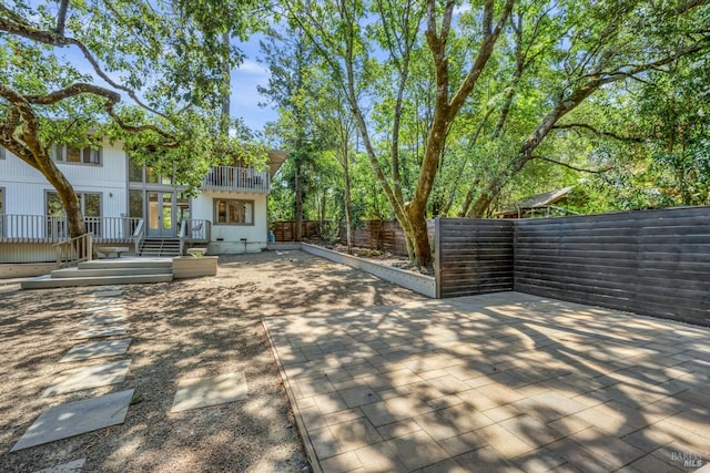 exterior space featuring a wooden deck and a patio area