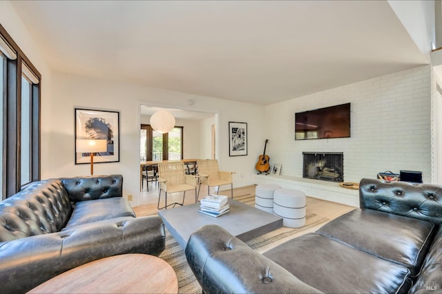 living room featuring a brick fireplace and wood-type flooring