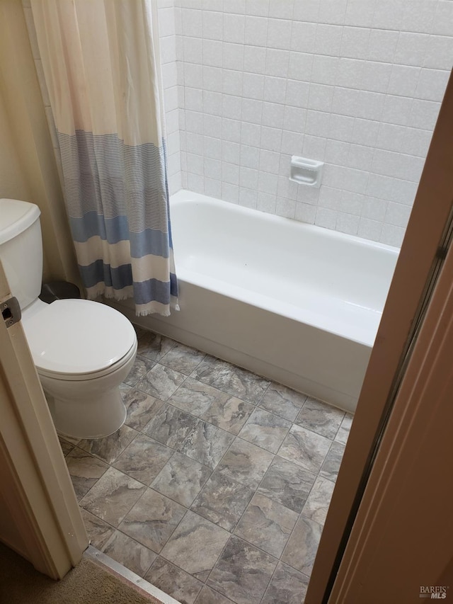 bathroom featuring shower / bathtub combination with curtain and toilet