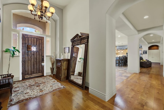 entrance foyer with a notable chandelier, a high ceiling, and light wood-type flooring