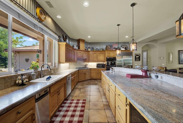 kitchen with light tile patterned flooring, decorative light fixtures, sink, decorative backsplash, and black appliances