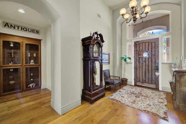 foyer entrance with wood-type flooring and an inviting chandelier