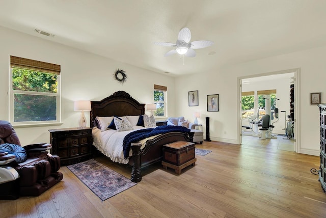 bedroom with multiple windows, ceiling fan, and light wood-type flooring