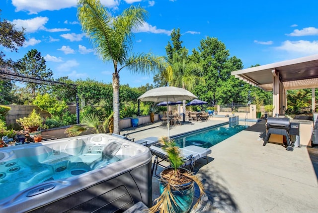 view of pool with a hot tub, a patio, and a grill