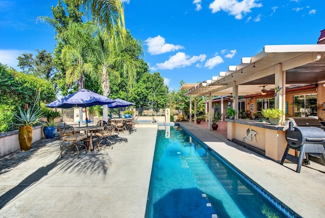 view of swimming pool featuring a grill, an outdoor bar, and a patio area