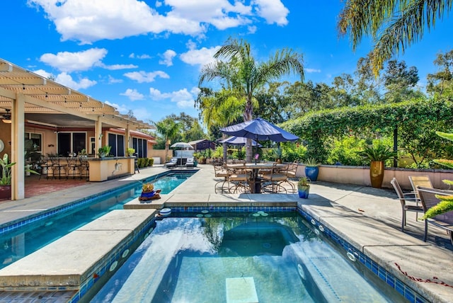 view of swimming pool featuring an in ground hot tub, a bar, and a patio