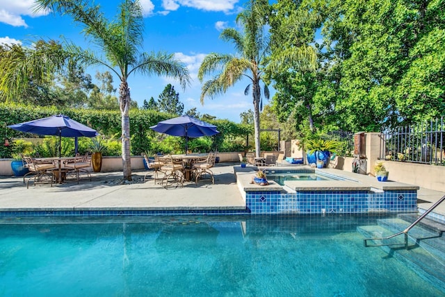 view of pool with a patio area and an in ground hot tub