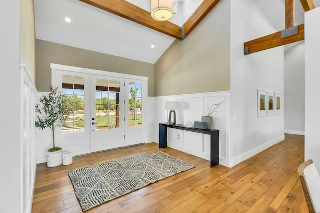 entryway featuring high vaulted ceiling, french doors, beamed ceiling, and light wood-type flooring