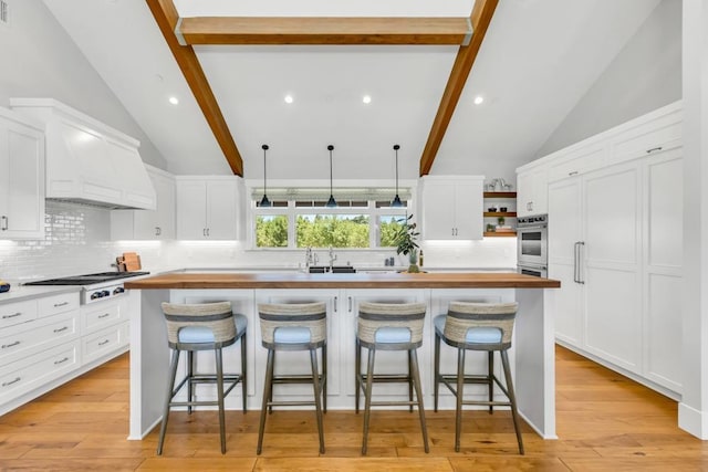 kitchen with white cabinetry, stainless steel gas stovetop, and a center island