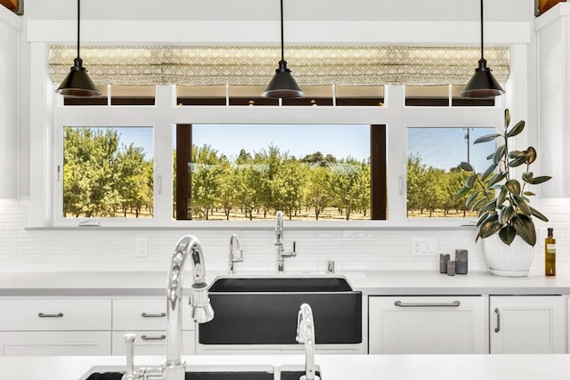 interior space featuring pendant lighting, decorative backsplash, and white cabinets