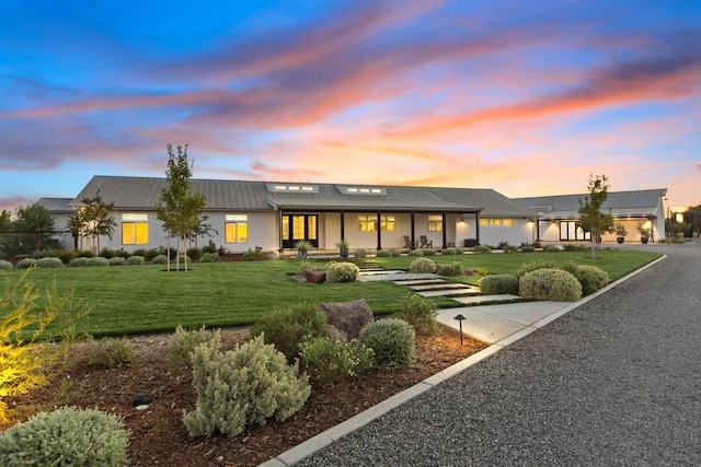 back house at dusk featuring a yard