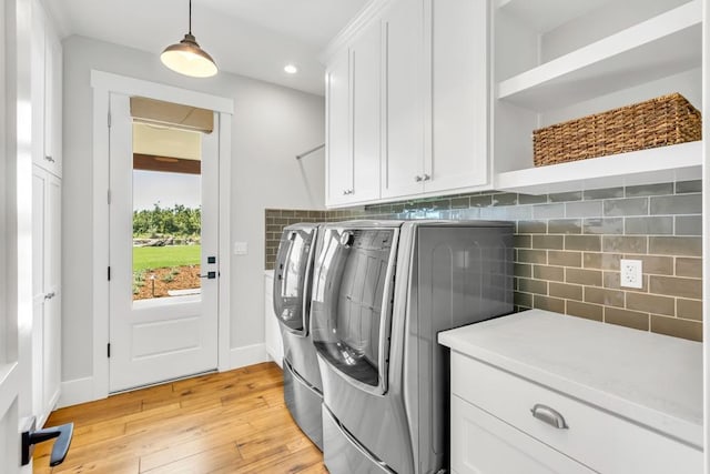 laundry area with cabinets, independent washer and dryer, and light wood-type flooring