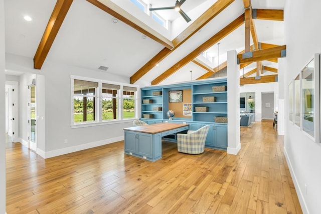 kitchen with a breakfast bar, beam ceiling, a skylight, a center island, and light wood-type flooring