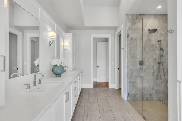 bathroom with vanity and a shower with door