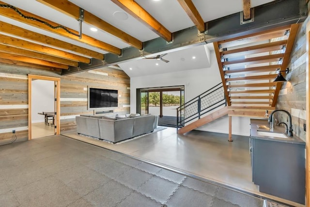 unfurnished living room with wooden walls, sink, and vaulted ceiling with beams