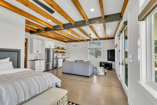 bedroom featuring sink, stainless steel fridge, beam ceiling, a wall mounted air conditioner, and concrete floors