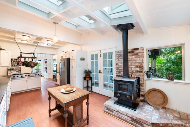 12130 Hwy 116, Guerneville, CA 95446 - living area featuring a wood stove, healthy amount of natural light, light wood finished floors, beamed ceiling, and coffered ceiling