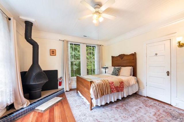 12130 Hwy 116, Guerneville, CA 95446 - bedroom with wood finished floors, a wood stove, crown molding, and a ceiling fan